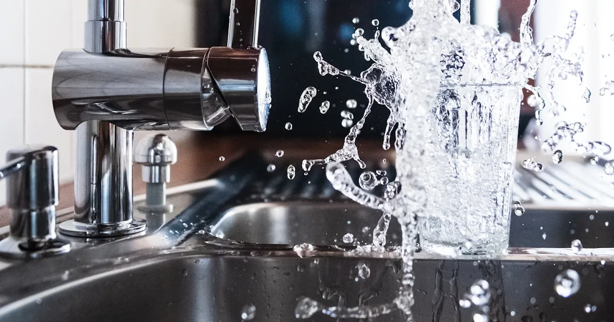 Tap water filling a glass at a kitchen sink — Palm Beach County water no longer contains added fluoride